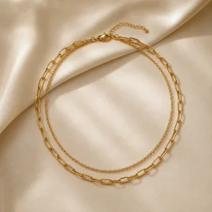 Double-layer gold-tone chain necklace on ivory satin
