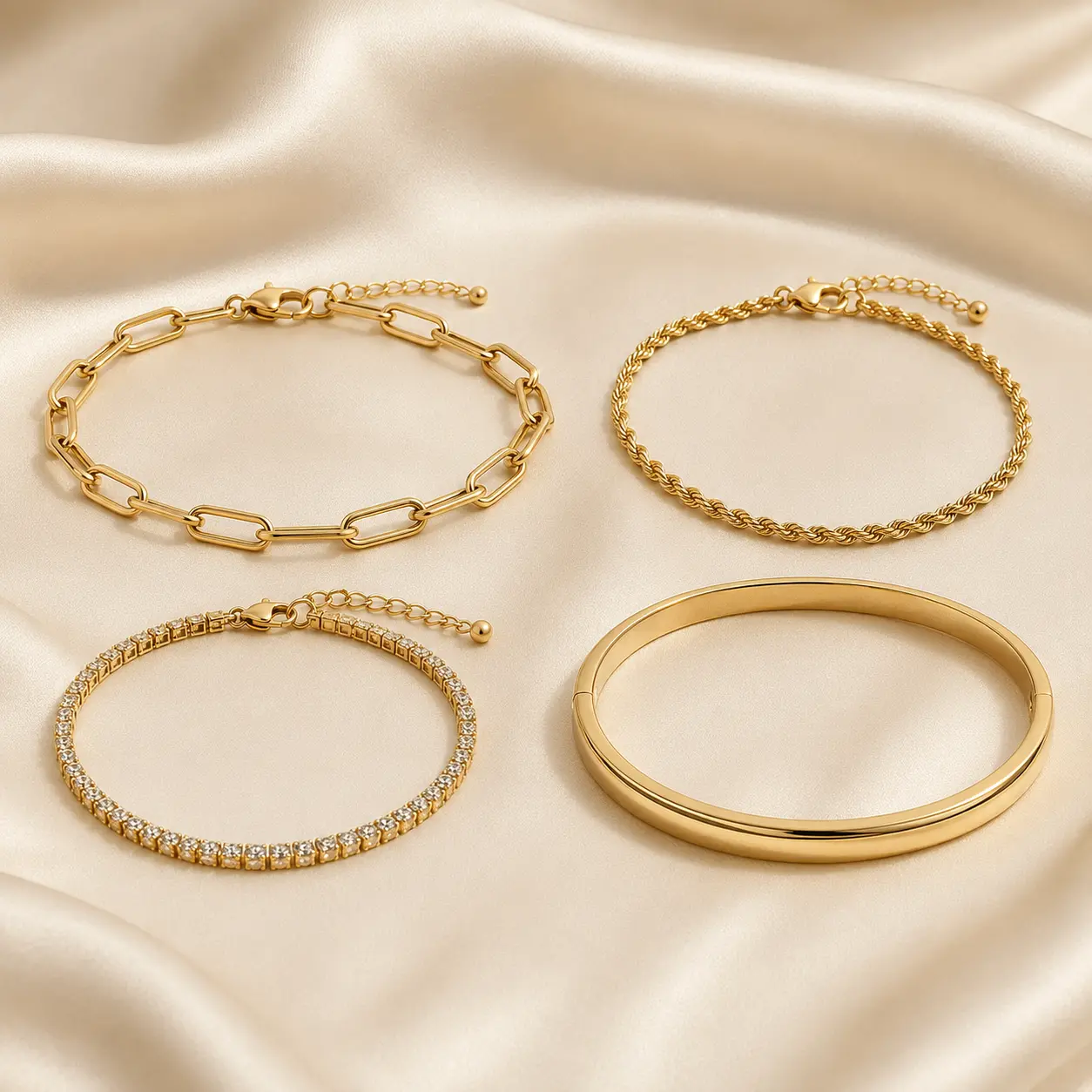 Curated gold-tone Ruvia bracelet collection on ivory silk